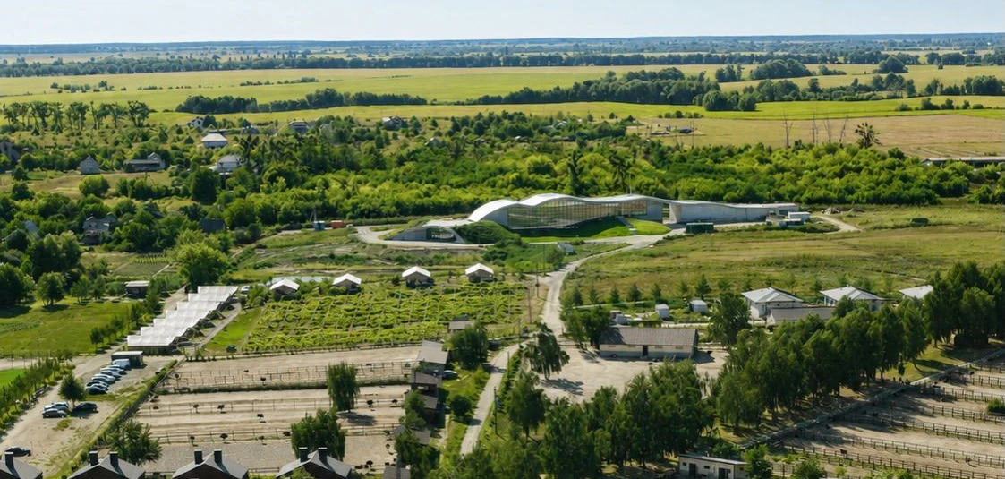 Аерофото території дистилерії в Ясногородці: поля, будівля з хвилястим дахом на горизонті, зелена територія